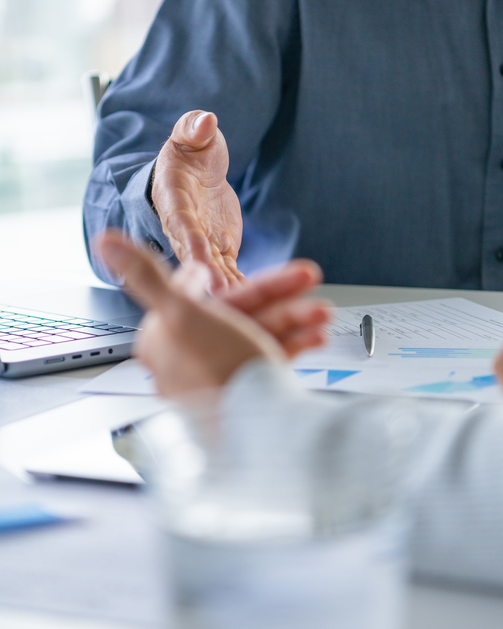 Zwei Geschäftspartner besprechen Kennzahlen und Unterlagen am Tisch